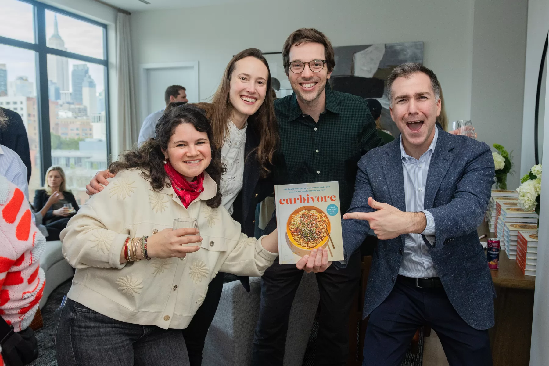 Guests posing with a featured book at a launch event