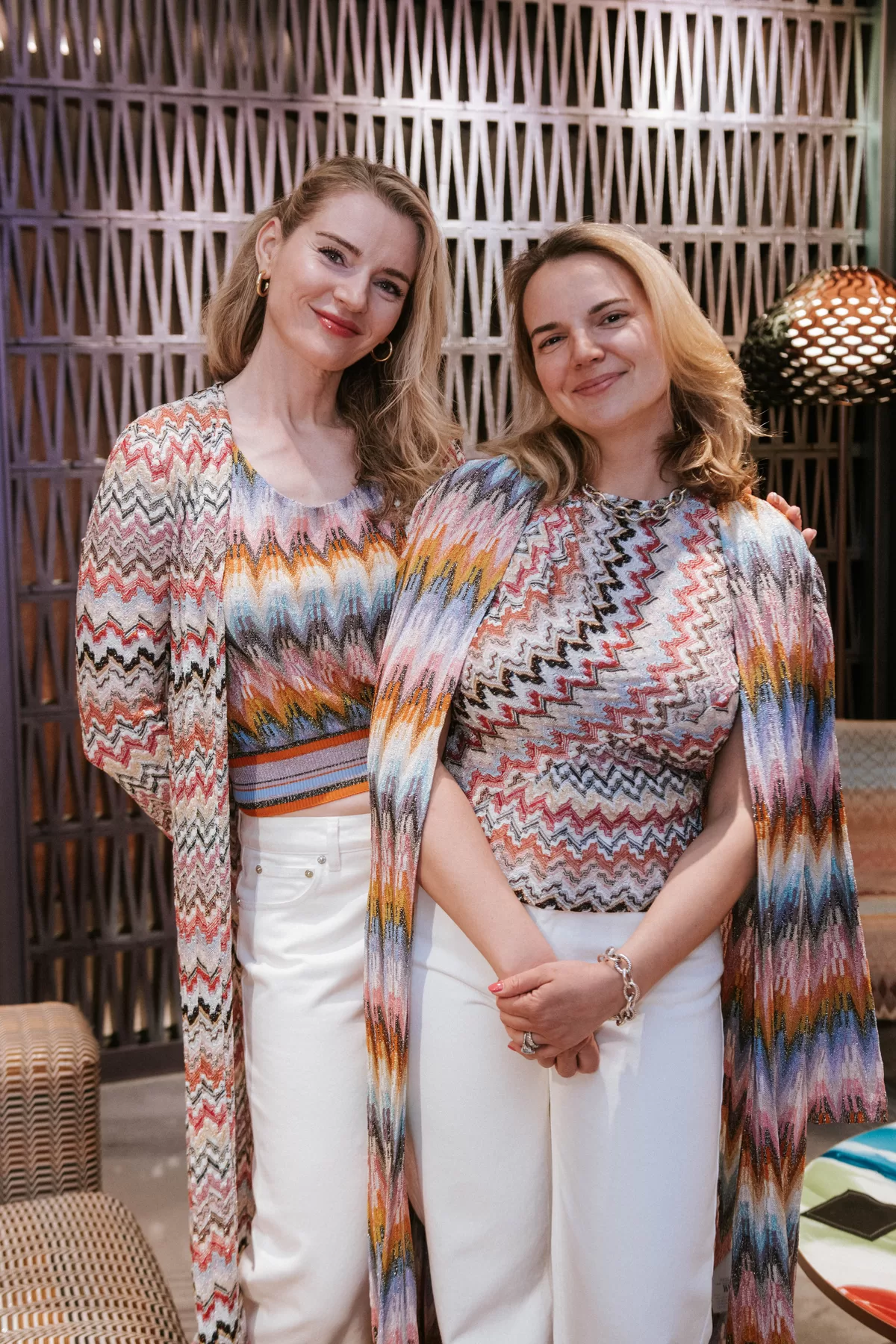 Two women modeling coordinated looks at a shopping event
