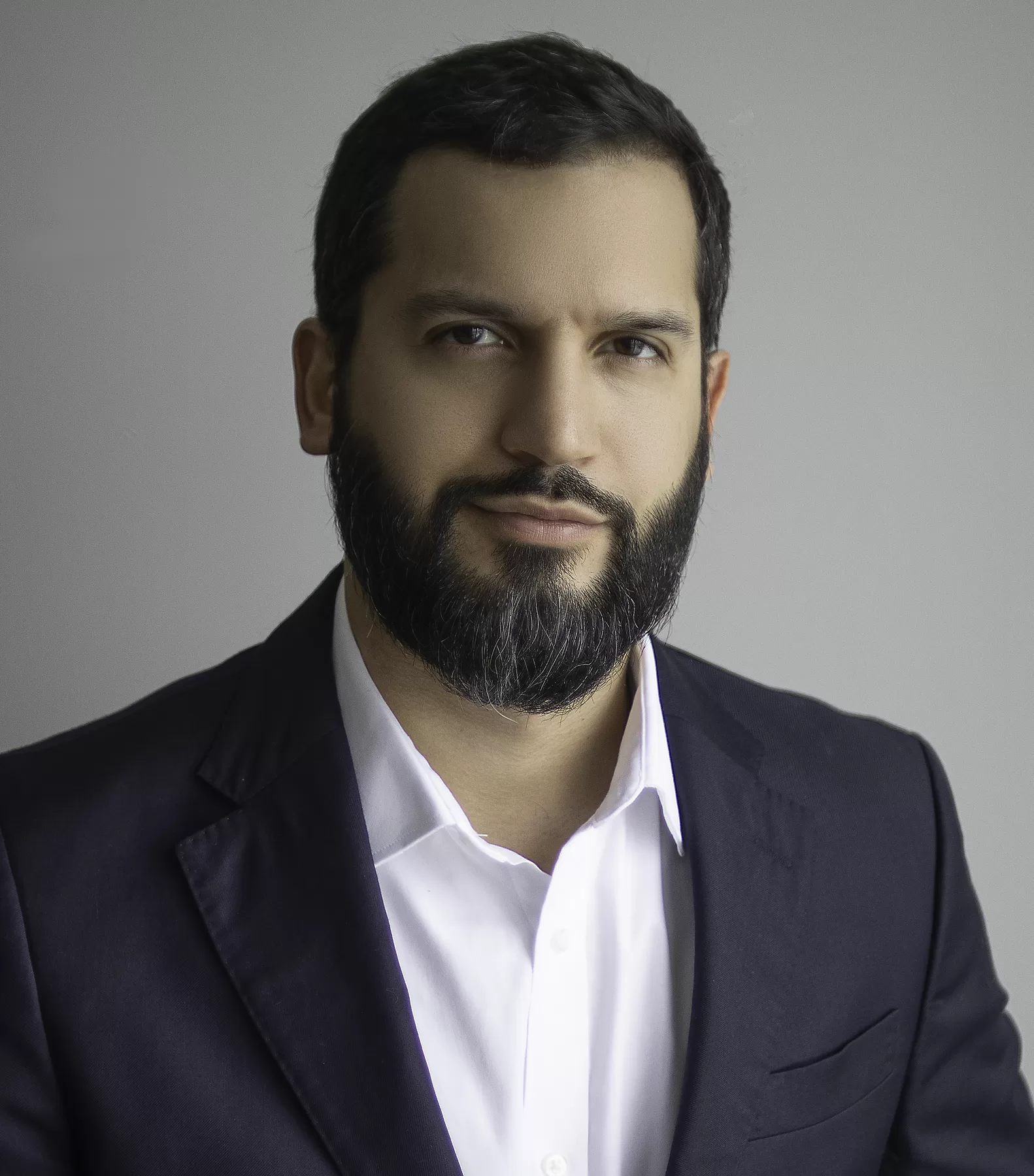 Editorial male headshot in a dark suit
