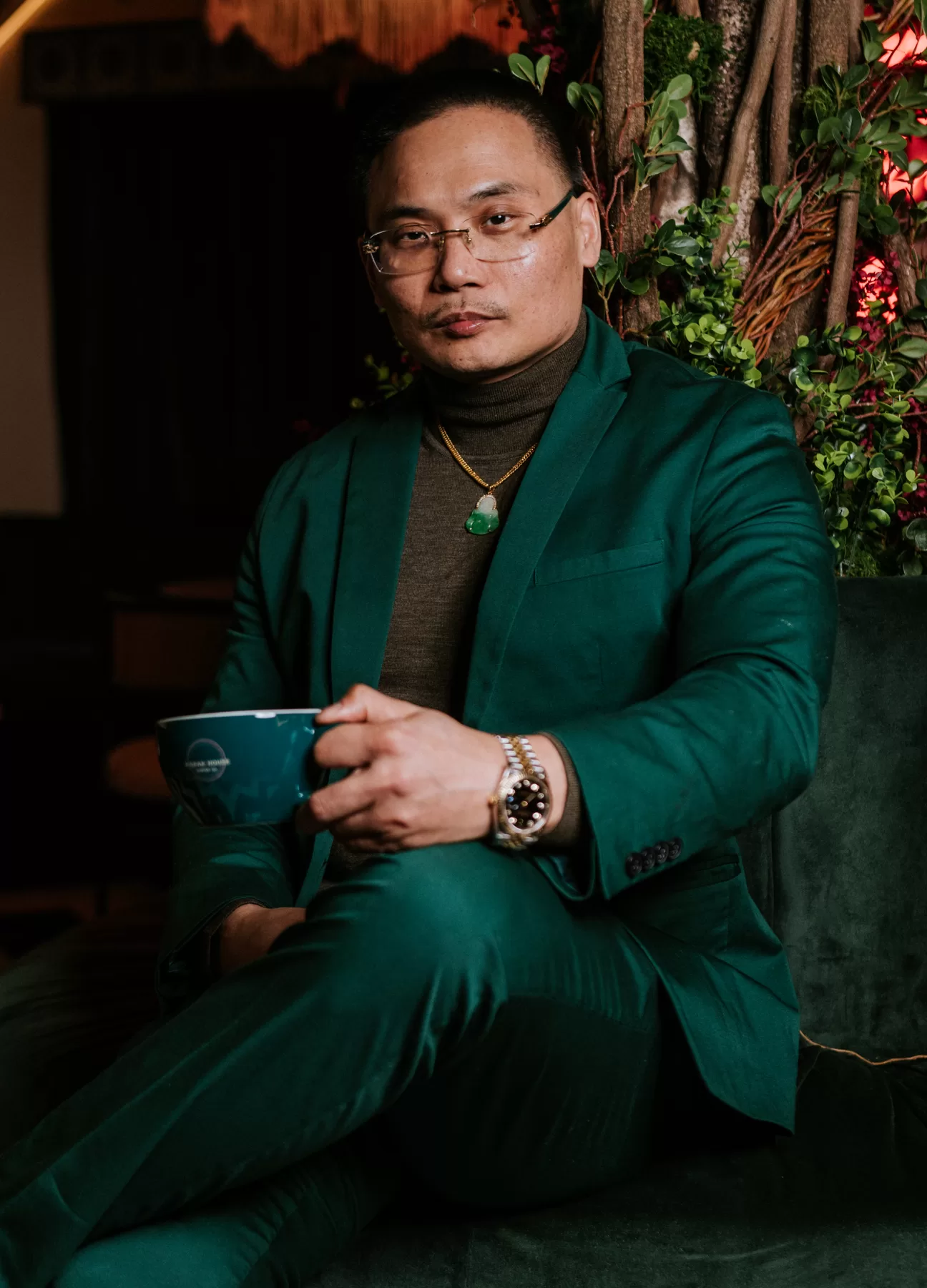 Man in a green suit photographed in a dramatic interior