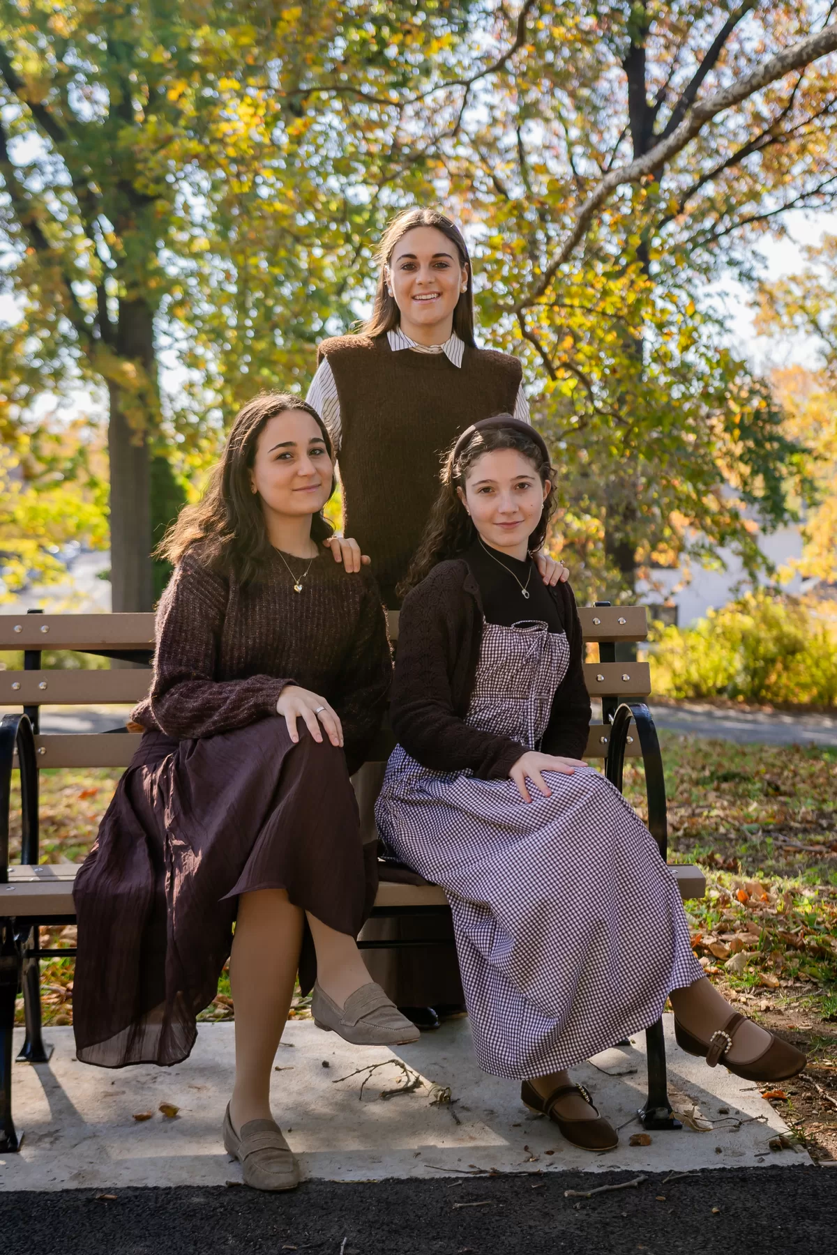 Three women photographed together outdoors in autumn light