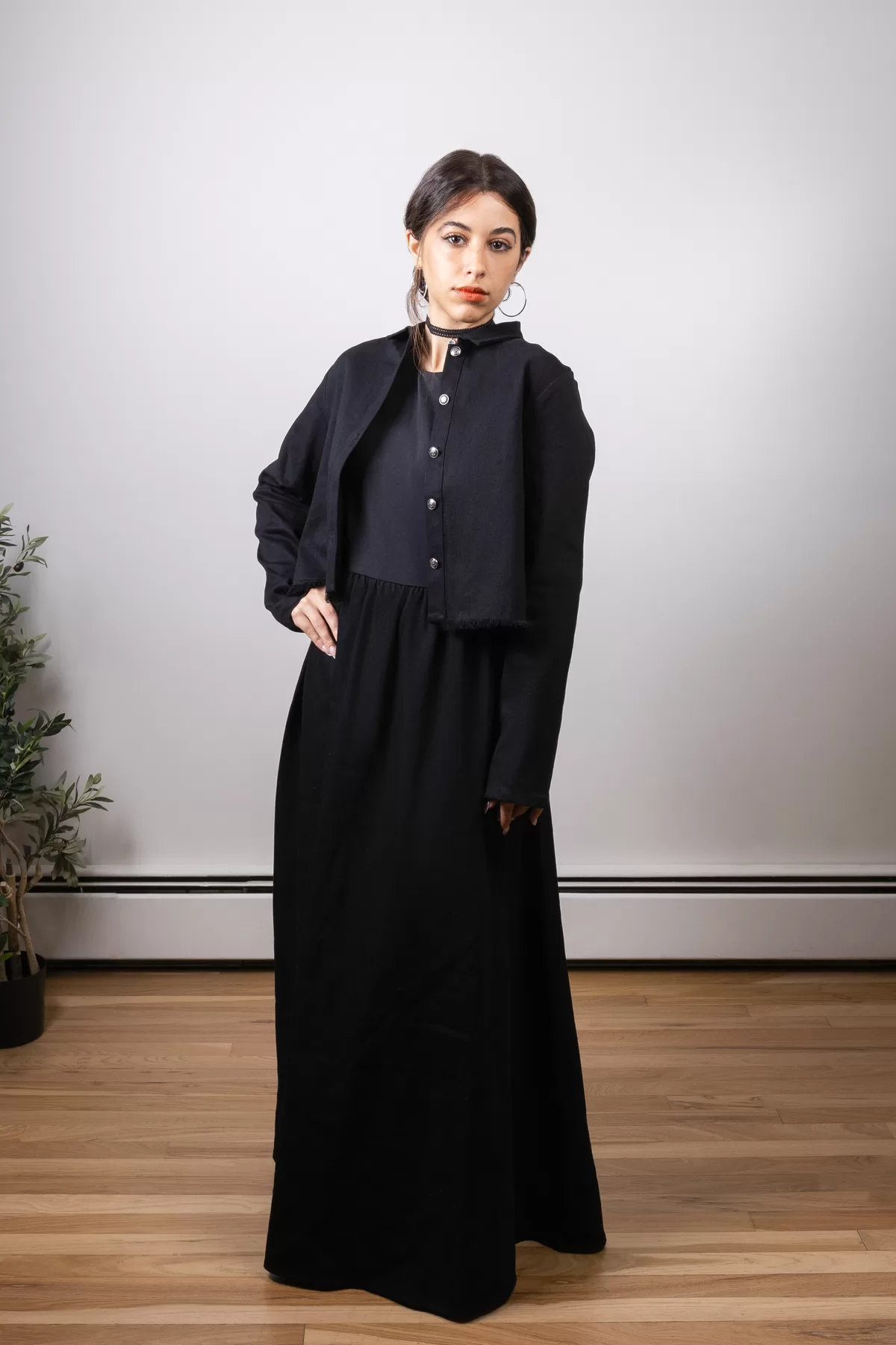 Woman modeling a black fashion look in a clean studio setting