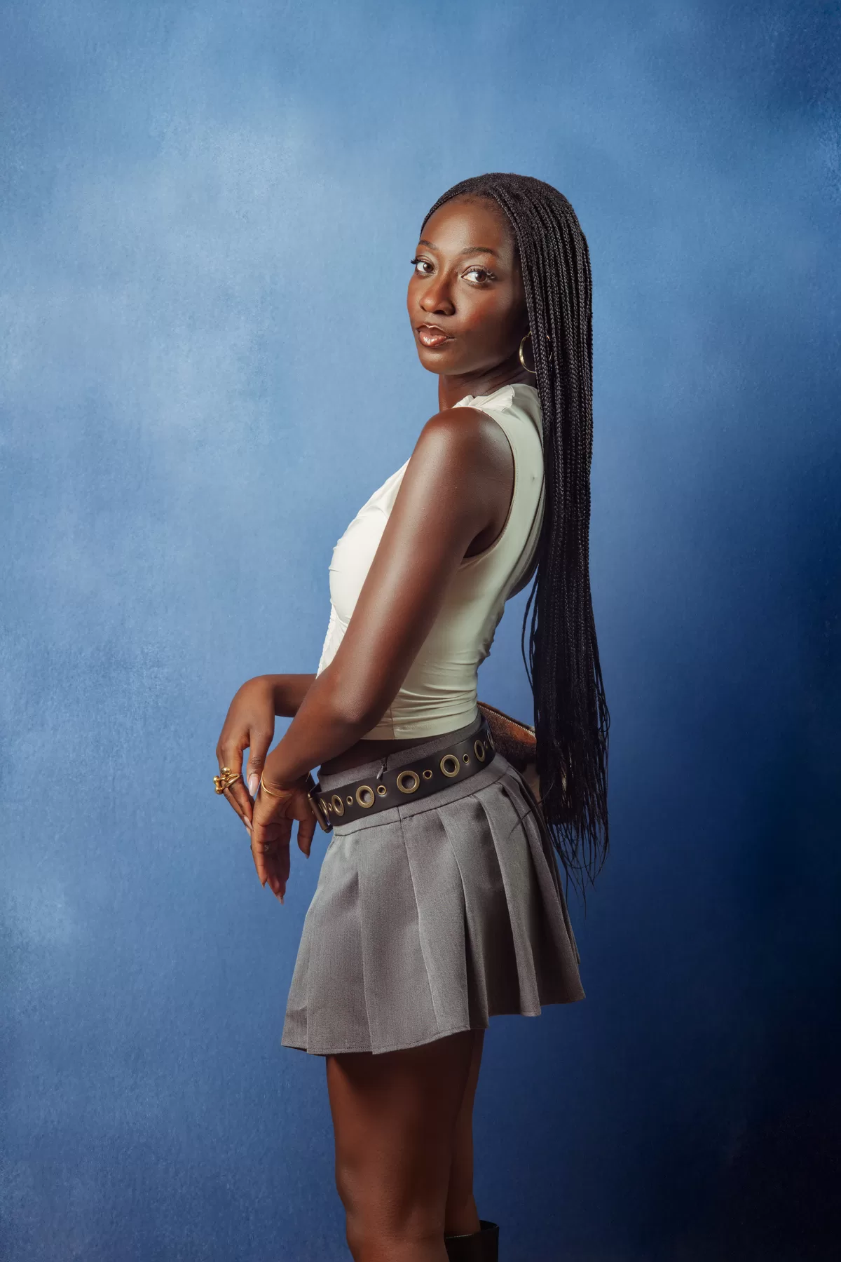 Young woman posing for an editorial studio portrait against a blue backdrop