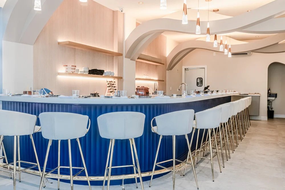 Curved blue bar with white stools and a sculpted ceiling at Otoro, photographed before service