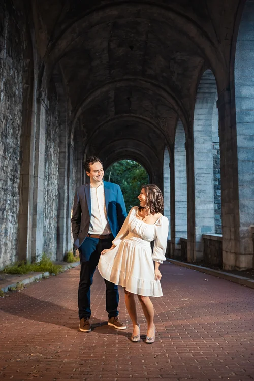 Engaged couple photographed beneath a stone arch